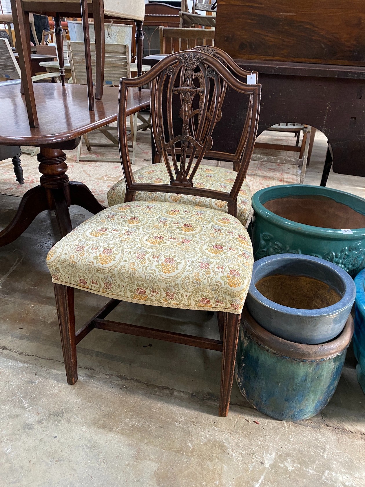 A pair of George III carved mahogany shield back dining chairs